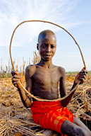 Lebuk, a tribal village, Karo boy sitting on roof of hut