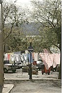 Portugal: Lisbon, Ajuda, laundry hanging in street behind street sign and in front of parked cars